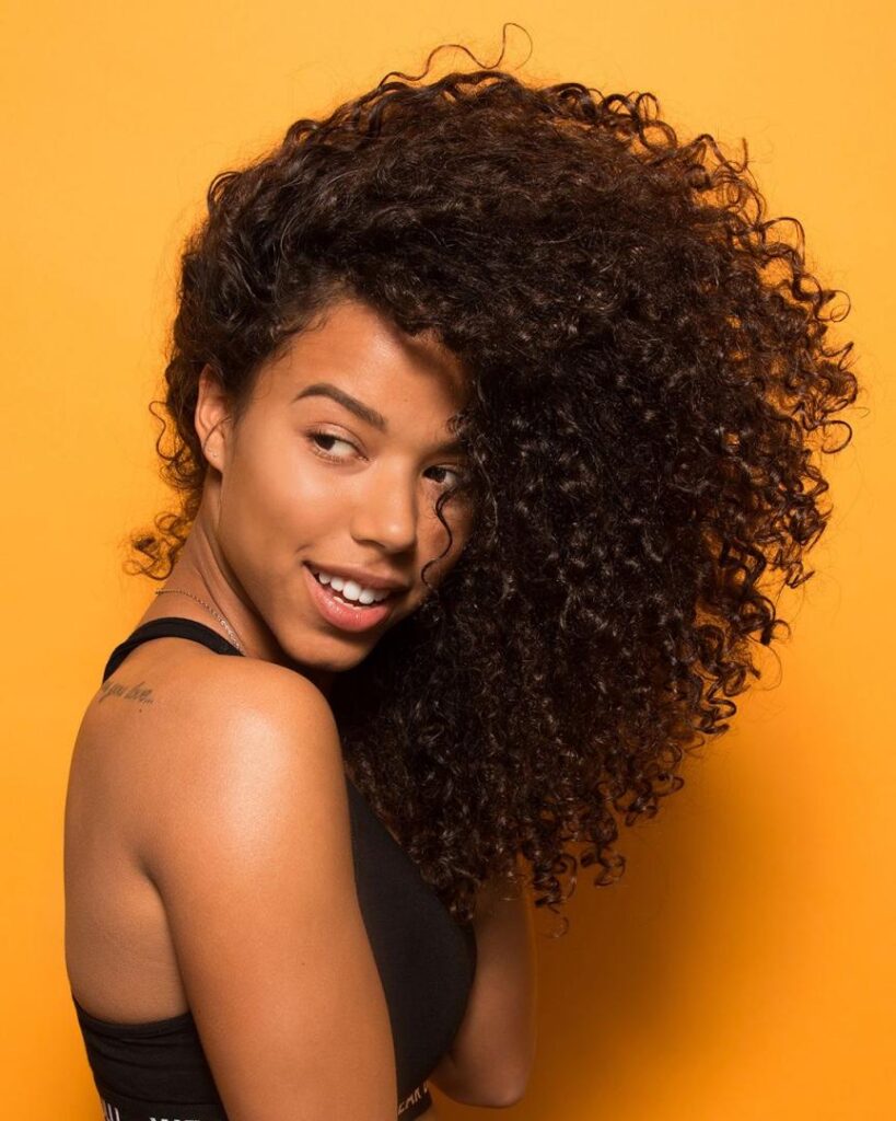 mujer posando su cabello rizados